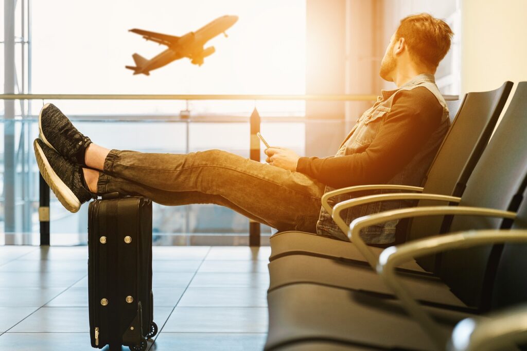 Passenger at airport with suitcase, airplane in background