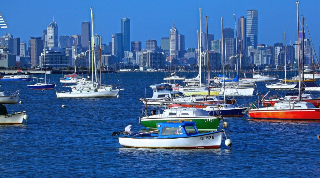 Small boats on the water with Melbourne in the background during tours transfers Melbourne